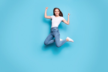 Full size photo of cute lady raising fists looking wearing white t-shirt denim jeans sneakers...