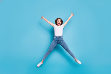 Fototapeta na wymiar Full size photo of cheerful youth raising hands shouting wearing white t-shirt denim jeans isolated over blue background
