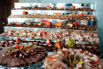 Cold cuts. Meat delicatessen plate. A variety of processed cold meat products Assorted meat products including ham and sausages. Thin slices of ham on cutting.