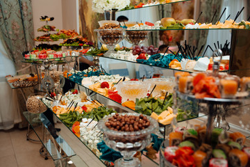 Cheese plate and variety of appetizers on table on event catering. Cheese plates served with grapes, jam, figs, crackers and nuts. Different cheese on corporate party event or wedding celebration