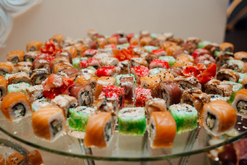 Japanese Cuisine -Buffet catering style Sushi Set in restaurant - salmon Maki Sushi. Appetizing sushi set from maki, rolls, nigiri in close-up. Mixed sushi plate