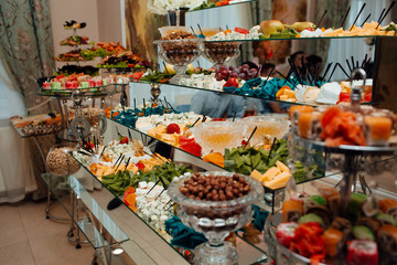 Cheese plate and variety of appetizers on table on event catering. Cheese plates served with grapes, jam, figs, crackers and nuts. Different cheese on corporate party event or wedding celebration
