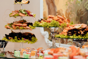 Beautifully decorated catering banquet table with different food snacks and appetizers on corporate christmas birthday party event or wedding celebration. Delicacies and snacks in the buffet. 