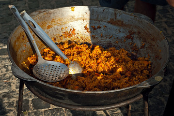 The food is cooked in a large pot on the fire. Field cuisine at the festival.