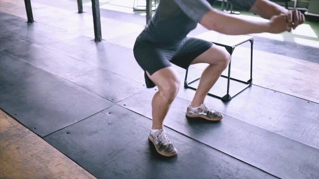 Effective exercises for a great fit. lunch short workout. Man squats at gym. Effective powerlifting squatting. Male fitness instructor showing squat exercise at modern plase.