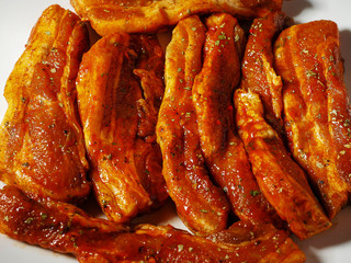 Raw pork belly portions marinated in Korean style. Close up.