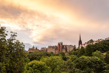 Fototapeta na wymiar Edinburgh city at sunrise with bright orange sky and gothic church architecture