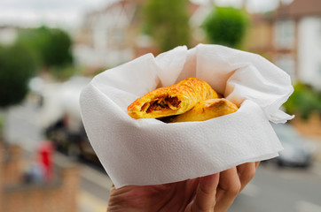 Delicious pulled pork and bourbon filling baked in saffron pastry in hand
