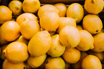 Harvest of lemons. Citrus yellow background. Lemons in box. Sour fruits for health. Hello, Autumn. Vegetarianism. Lemons top view. Place for an inscription. Copy space.