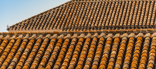 Traditional old Spanish ceramic roof tiles on a building, characteristic elements of Mediterranean architecture