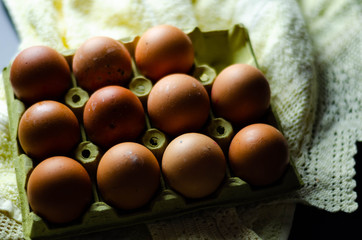 Fresh raw eggs lined up in a row in a cardboard egg carton on the rural table