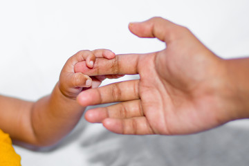 A asian baby's hand holding her mother finger