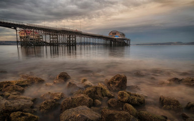 Low tide at dusk at Mumbles pier in Swansea, South Wales UK, showing Mumbles pier and lifeboat station.