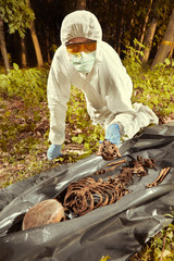 Collecting of human remains to plastic body bag by police technician for observing