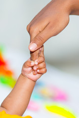 A asian baby's hand holding her mother finger