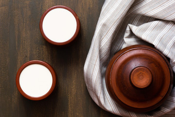 Top view of fermented boiled milk in clay pot on wooden background
