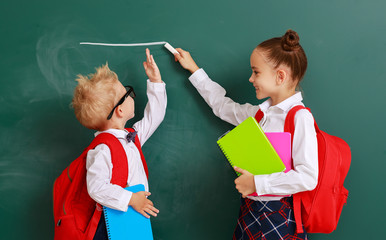 concept of   development in education. children boy and girl students measure growth about school blackboard.
