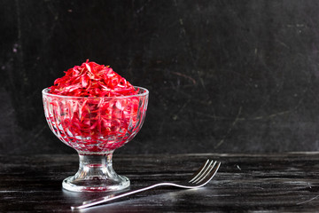 Raw beetroot, carrot and cabbage salad on black background