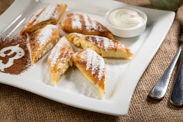 Sweet crepes with cheese and cream on plate