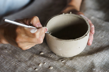 Female hands hold a bowl for casting clay products. Shaped method for making clay dishes. Handwork. Pottery making