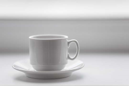 Empty white coffee cup on windowsill