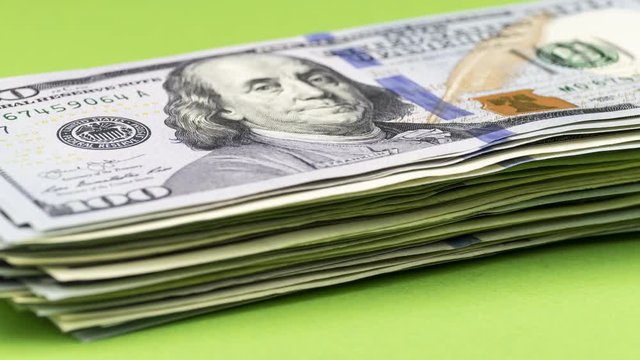 Spending money concept. Bundle of American dollars is decreasing one by one bill, becoming smaller and smaller. Stop motion animation.