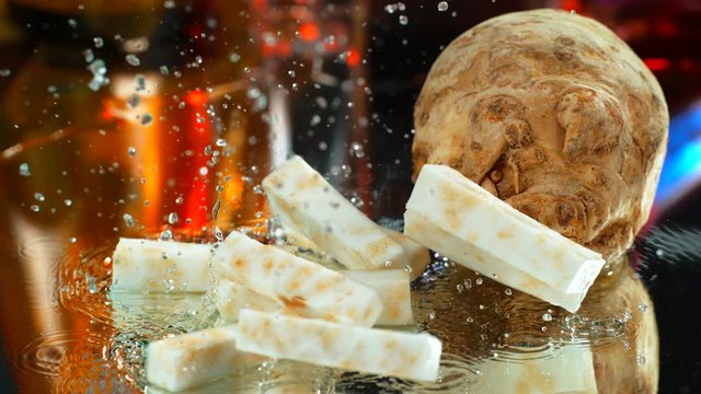 Sliced celery root falling on a table with water in slow motion? 4k, phantom