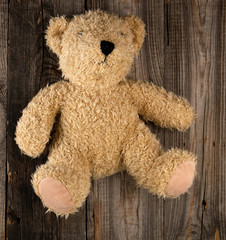 small brown old teddy bear, gray old wooden background