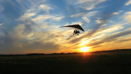 flying a hang glider at sunset