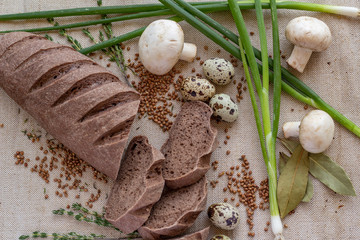 composition of dark sliced ​​bread with scattered buckwheat, sprigs of rosemary, fresh...