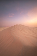 Obraz na płótnie Canvas Sun set in dessert outside of Abu Dhabi with pink and red sky UAE 