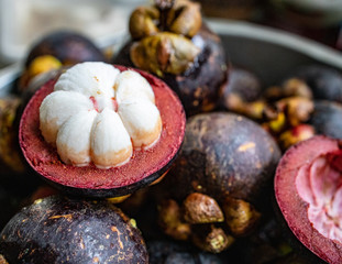 Mangosteen fruit cut open in half showing white flesh and purple shell. Mangosteen is  a queen of fruit in Thailand.  Shell  can be used for extraction of xanthose, a potent, antibacteria