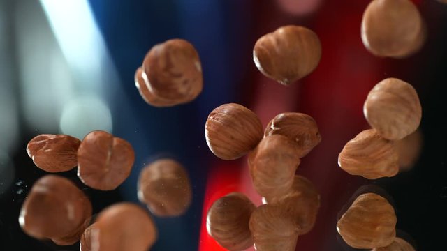 Many hazelnuts very slowly coarsely fall on the table on the background, Slow Motion, 4k, phantom