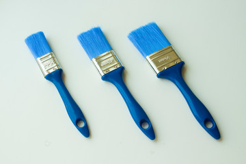  blue paint brushes on a white background of different widths
