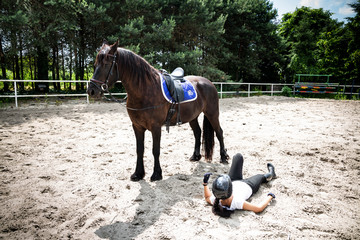 Falling from a horse. Riding accident. Injured woman