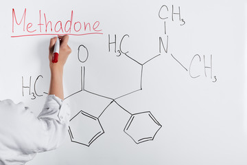 cropped view of woman writing methadone on white board