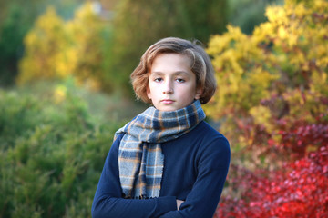 young boy in autumn park near the lake