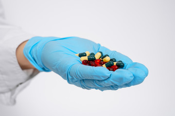Doctor holding pill capsule drugs in hand latex glove white background. Placebo drugs concept. Treatment and health care. medicine for various diseases hospital concept.