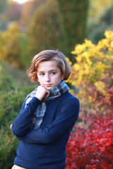young boy in autumn park near the lake