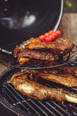 The chef is cooking meat on the grill. Golden rib steaks and chicken with grilled vegetables, delicious food