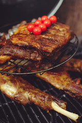 The chef is cooking meat on the grill. Golden rib steaks and chicken with grilled vegetables, delicious food