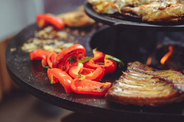 The chef is cooking meat on the grill. Golden rib steaks and chicken with grilled vegetables, delicious food