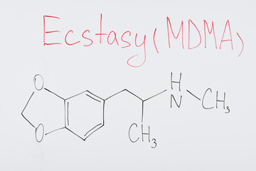 top view of white board with chemical formula and lettering ecstasy