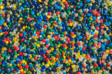 Fototapeta na wymiar Industrial colorful Polymeric dye. Plastic pellets. Colorant for plastics. Pigment in the plastic polyethylene granules background texture.