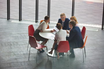 High angle view of colleagues planning while sitting during meeting at office