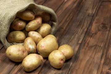 potatoes in a bag on a wooden surface