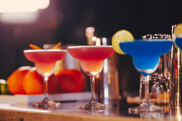 Set of cocktails on the bar counter. Night club, evening party. Lights bokeh on 