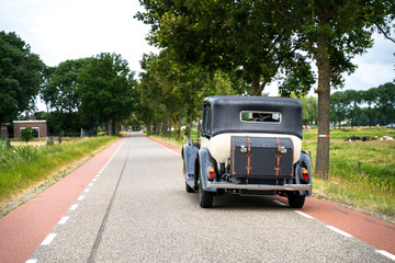 Classic wedding car driving on the public road on the way to a wedding