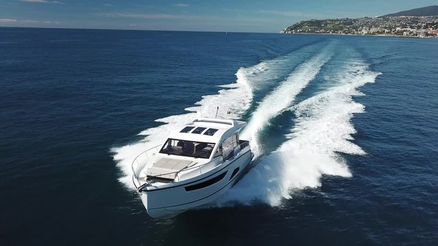 Aerial view of a luxury yacht navigating fast.