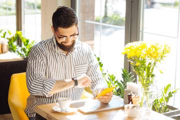 Positive good looking man checking the time